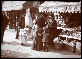 Ansicht von Frauen mit Kindern beim Einkaufen an einem Obst- und Gemüsestand in der 266 7th Avenue, New York, um 1900